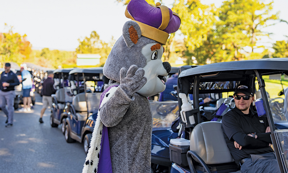 Duke Dog talks to a golfer at the JMU Homecoming 2025 Golf Tournament.