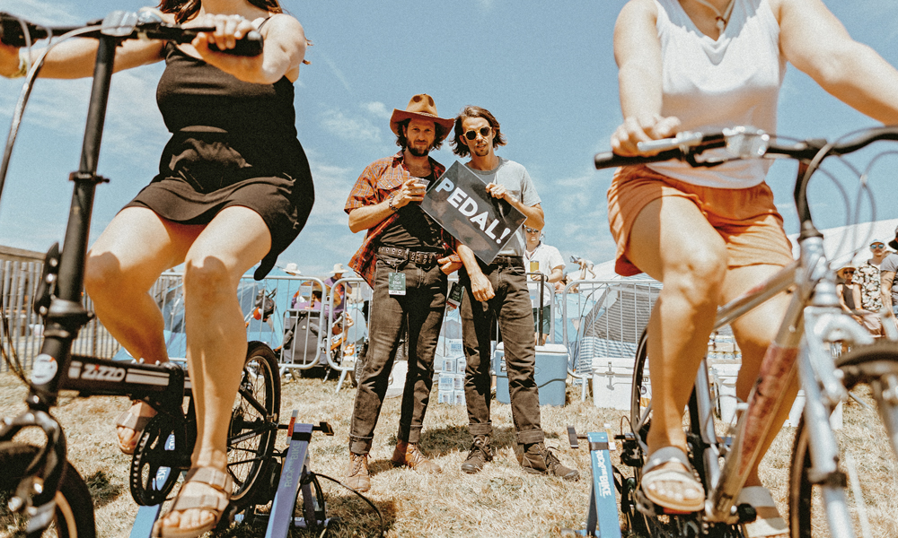 Illiterate Light hold a bike sign at the legendary Newport Folk Festival in Rhode Island
