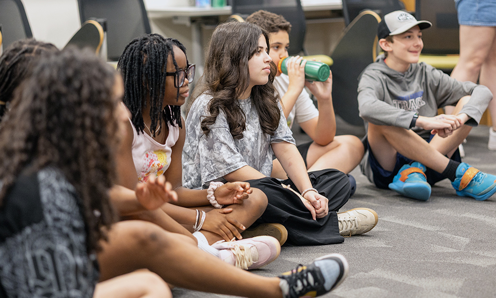 Headstrong campers sit cross-legged during an activity