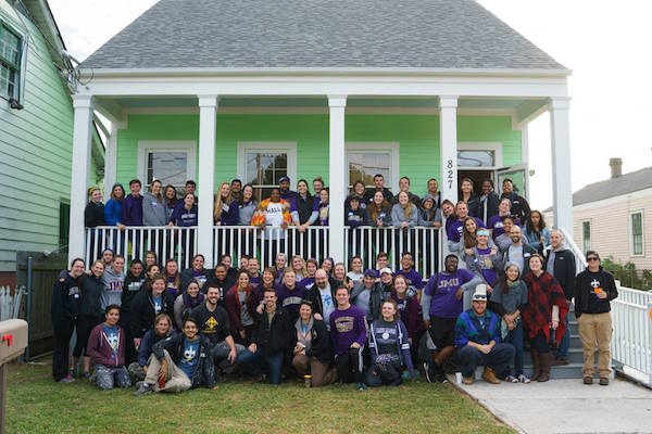 students in front of completed home renovation 