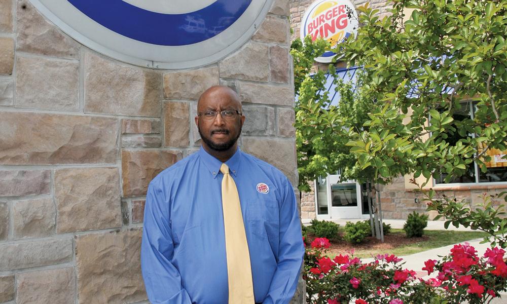 Gilbert Bland standing in front of a Burger King restaurant.
