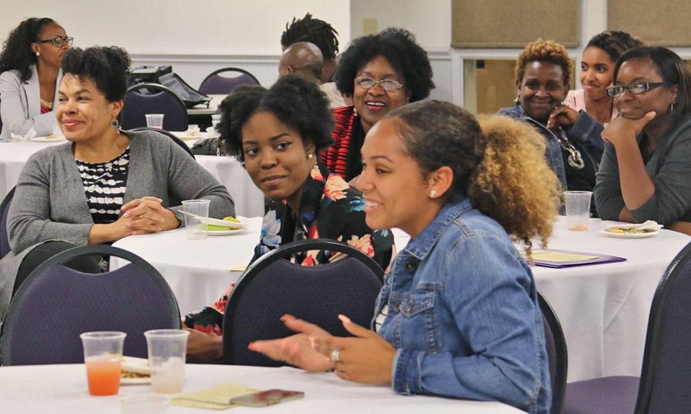 A group of Africana and Black women sitting at conference tables.