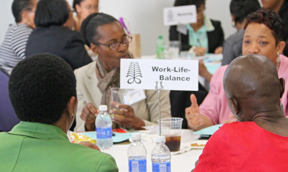 Close-up image of a few African and Black women at a conference discussion table.