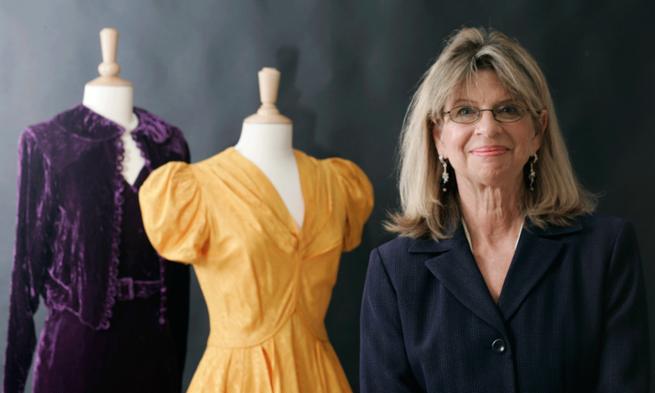 Image of Professor Pam Johnson with items from Dressing for Education exhibit