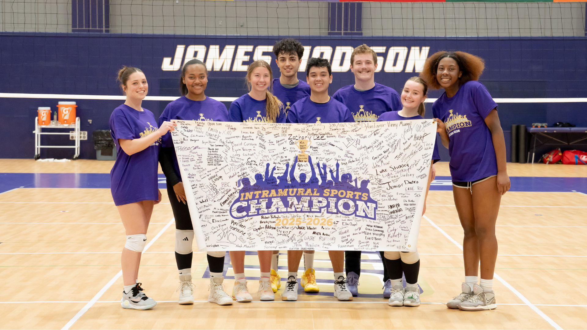 students holding up an intramural championship banner and celebrating