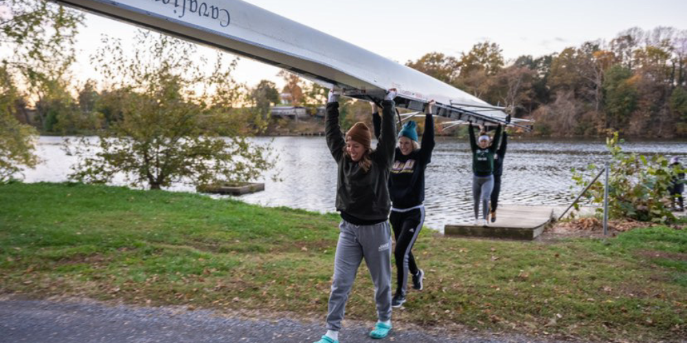 students caring a rowing boat