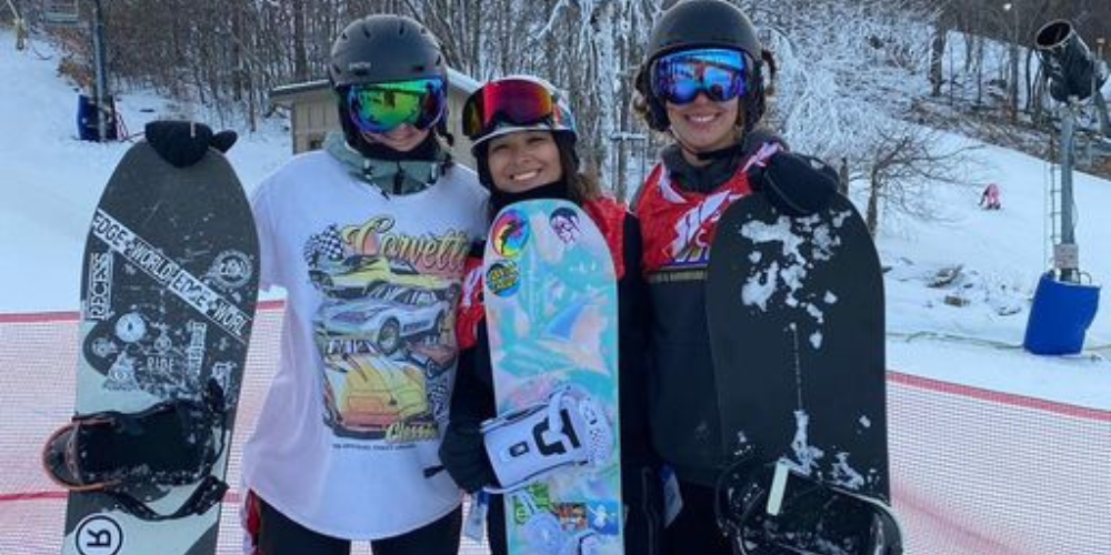 students holding snowboards