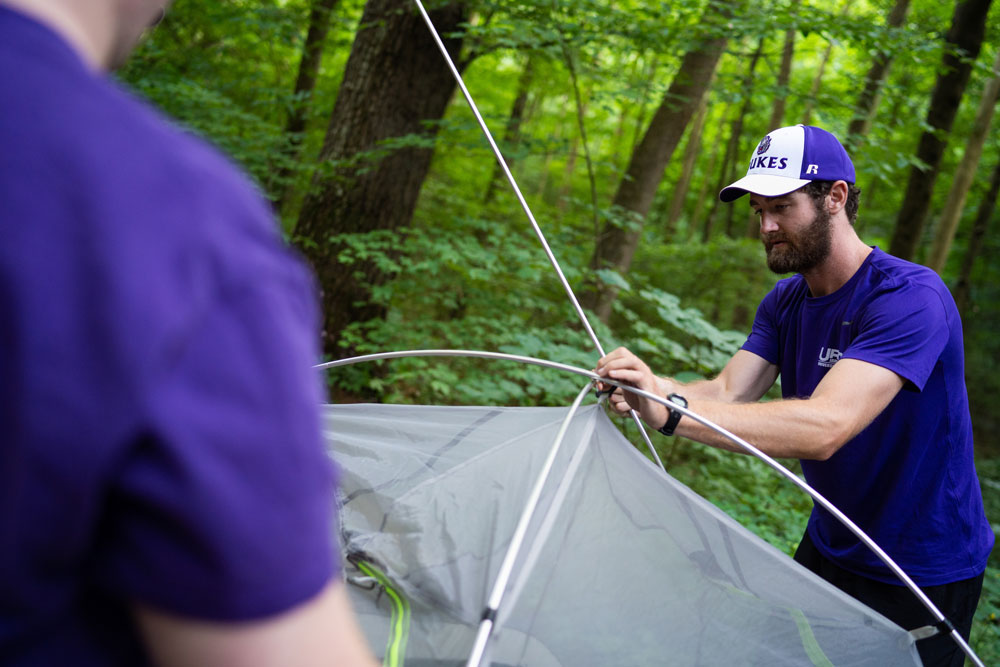 trip leader setting up a tent