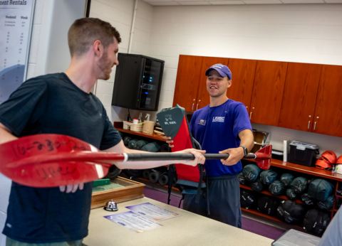 student handing a paddle to participant