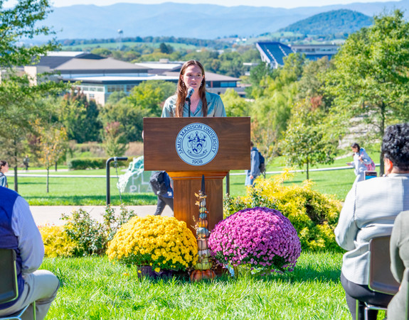 University student speaking at a podium outdoors