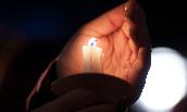 Closeup view of JMU student's hand holding candle as part of candlelighting ceremony