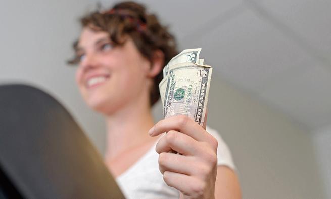 Photo of woman exercising with money in hand