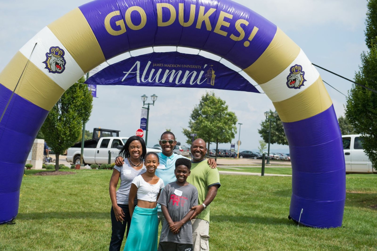 photo of family under archway that says James Madison University Alumni Association