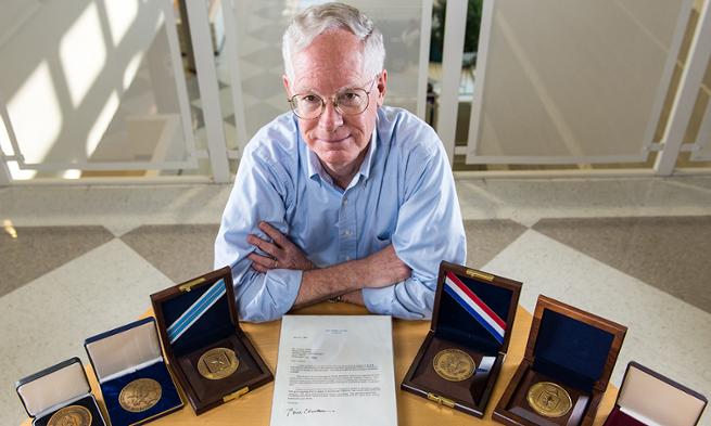Dr. Tim Walton with a display of some of his achievement awards