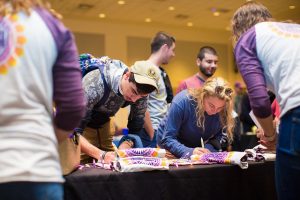 Photo of: students filling out contact information for housing groups