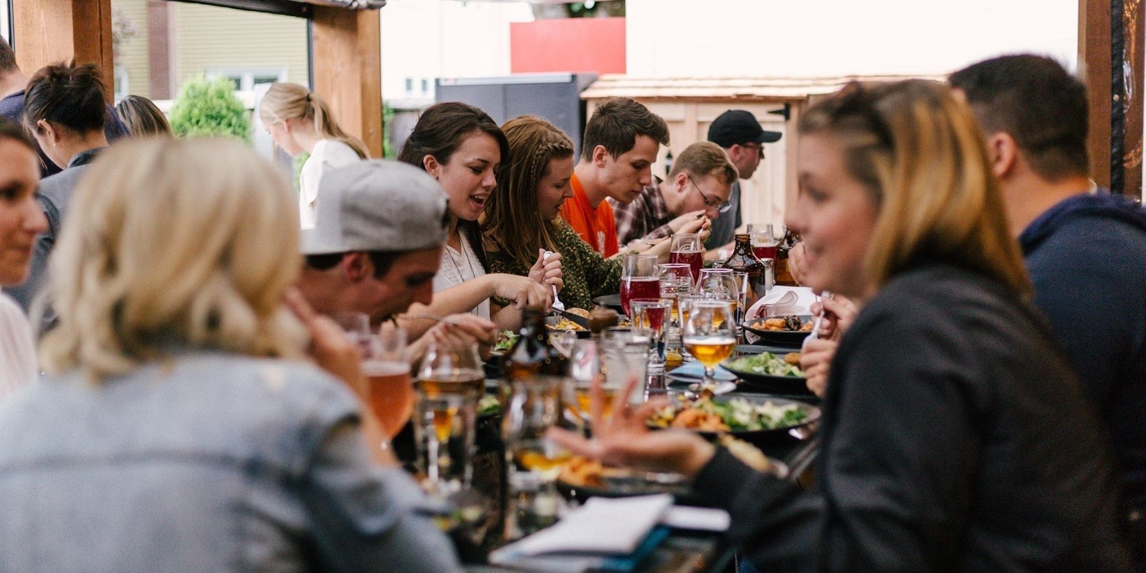 Group of young adults eating together at a restaurant.