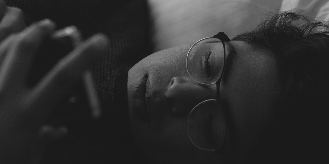 A person is looking at their phone in bed.