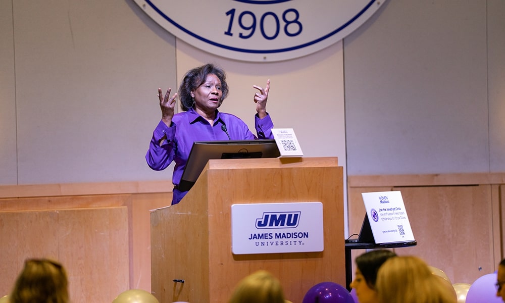 A speaker at a podium presenting at a James Madison University event.