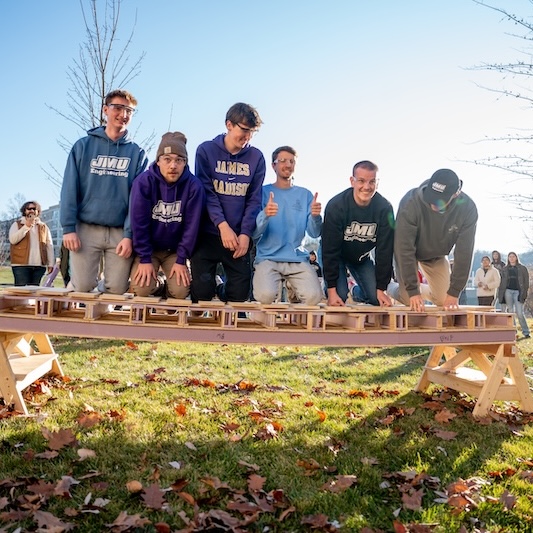 Students participating in a hands-on engineering project outdoors, showcasing teamwork and creativity.
