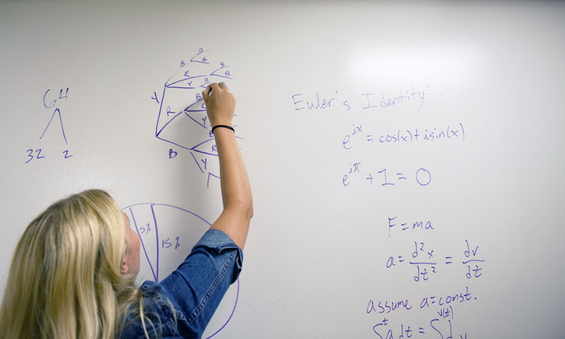 A student works a problem on a whiteboard