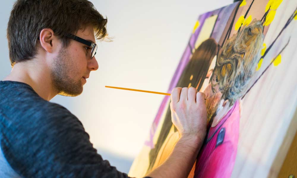 Studio art student Nathaniel St. Amour painting