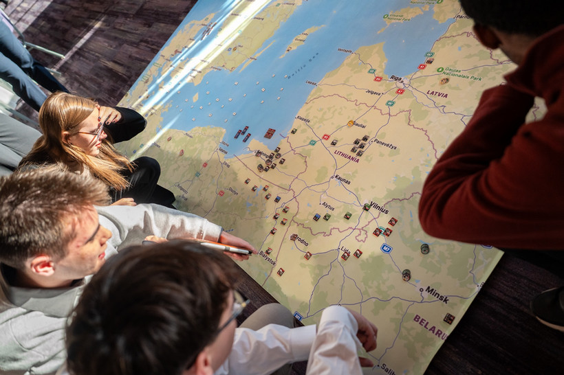Students gathered around a map of Lithuania and the Baltic Sea