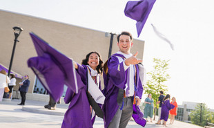 JMU graduates throwing their caps at camera
