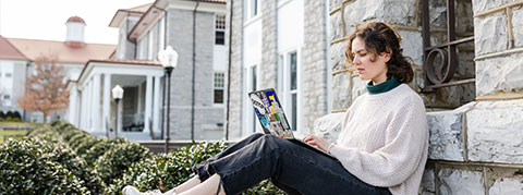 Photo of a student studying on the Quad