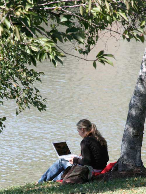 Student using laptop by Lake Newman