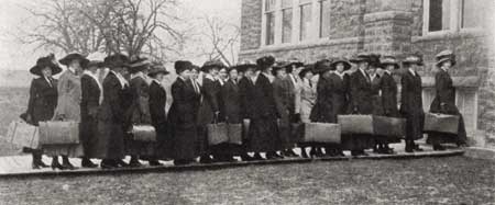 Freshman ladies of 1910 line up with their suitcases.