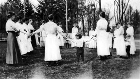 Students in a circle with kindergarten students.