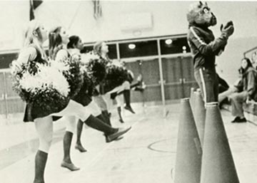 Early version of Duke Dog helps cheerleaders lead cheers.