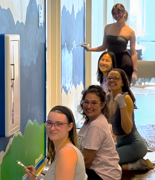 penny naden paints mural with kappa pi