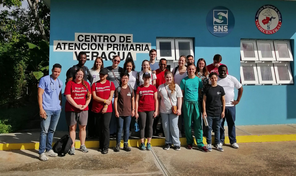 A group of Alternative Breakers pose in front of a rural health clinic: "centro de atencion primaria Veragua."
