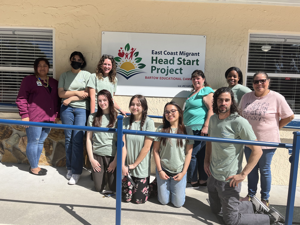 The 2023 East Coast Migrant Head Start group poses alongside employees outside of the organization's headquarters