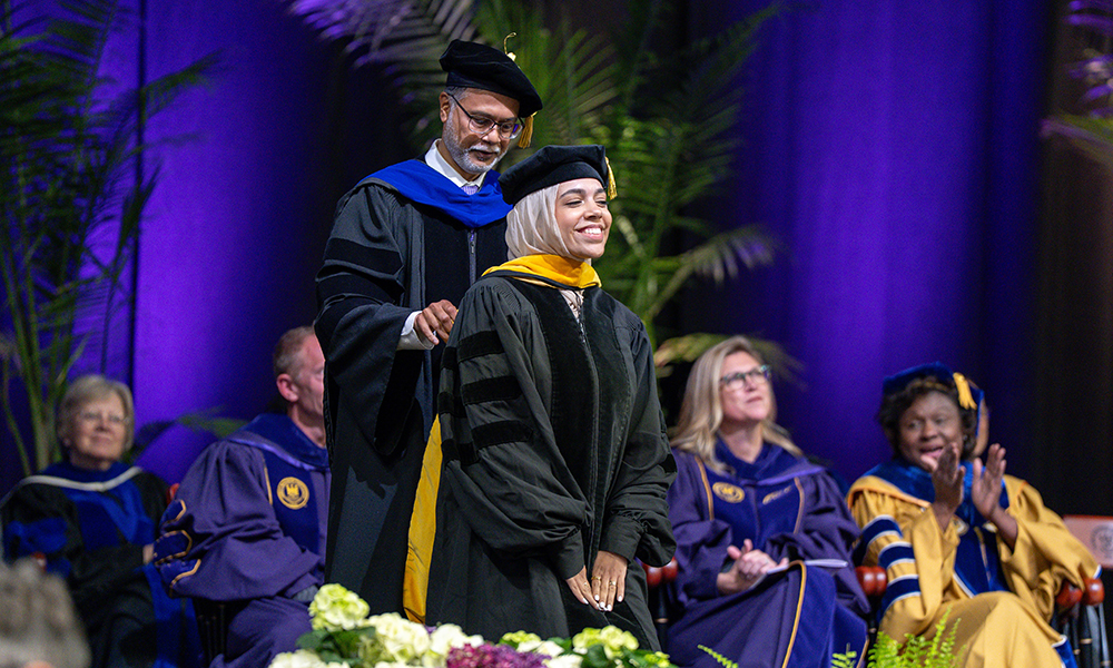 A CSD graduate student is hooded by department head Ayasakanta Rout