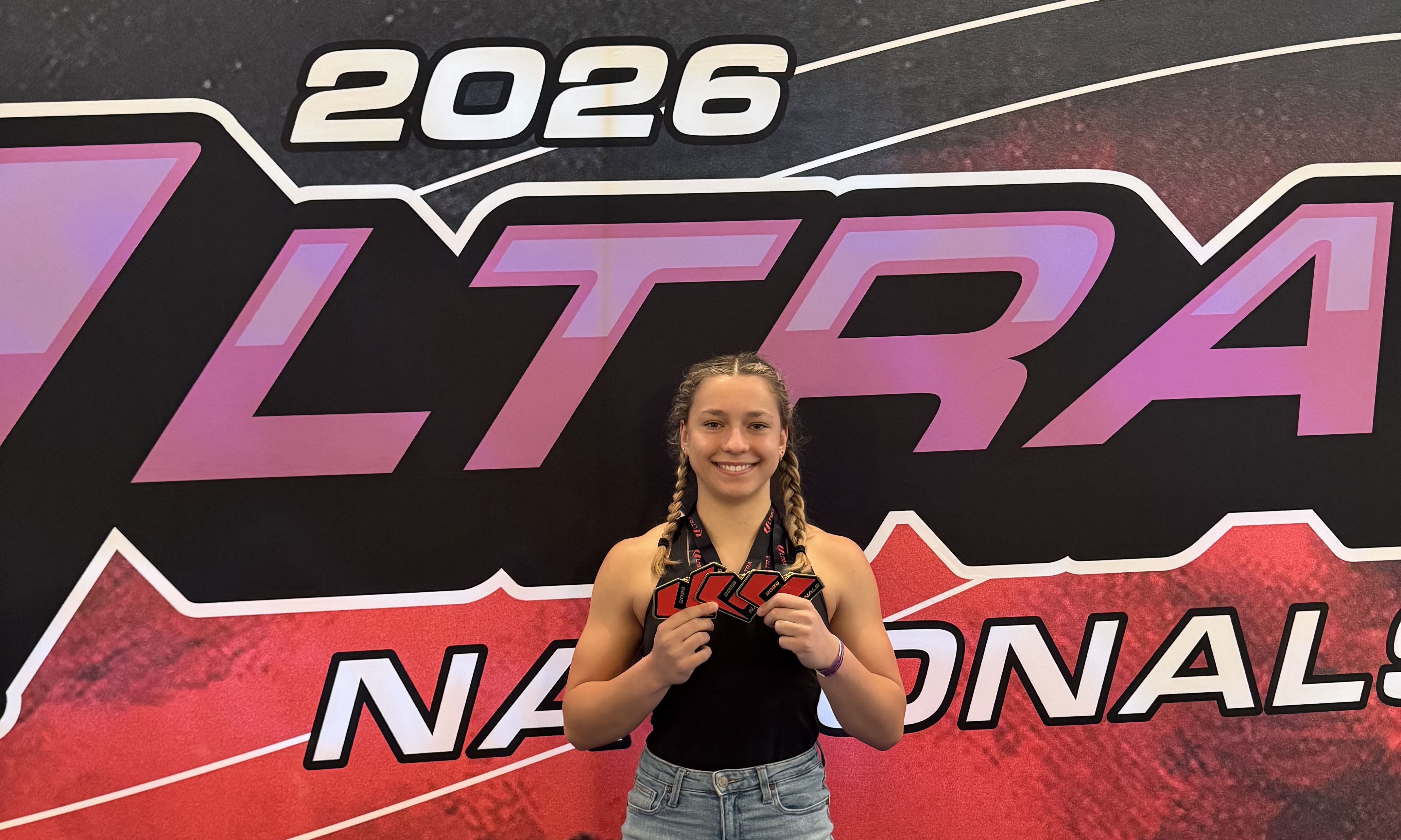 Photo of Mikayla Dolina standing with a medal.