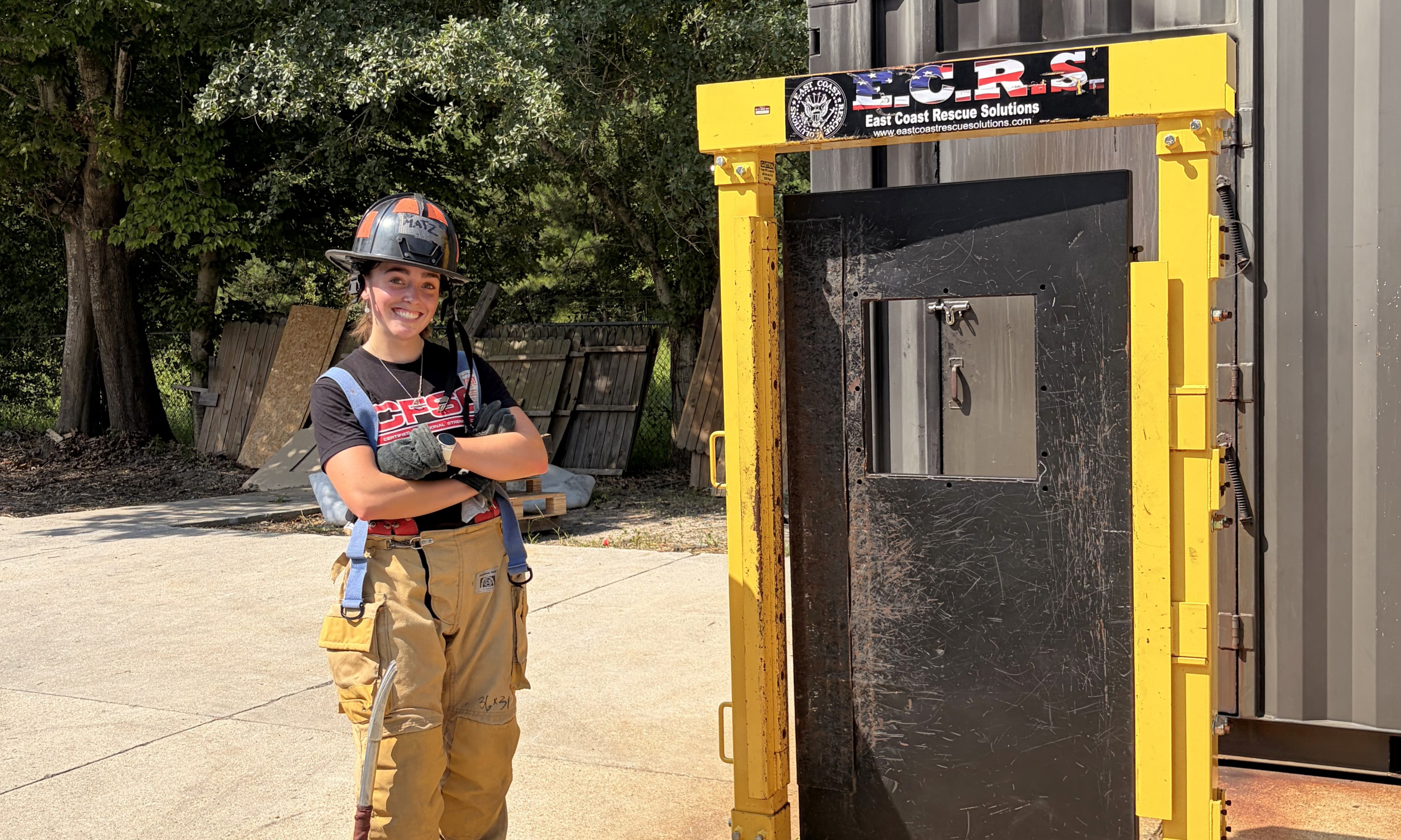 Aimee FitzPatrick standing in fire-fighting gear.