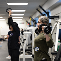 Two women lifting weights.
