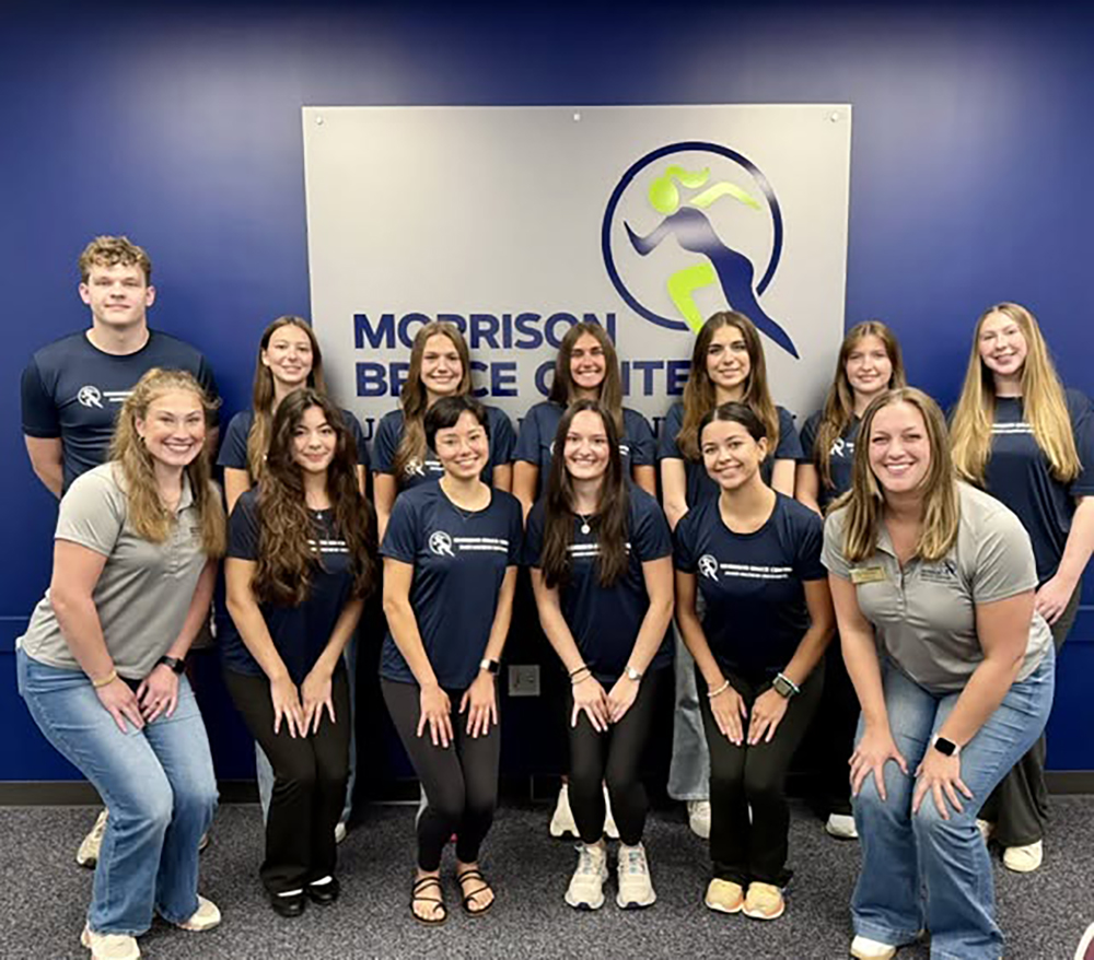 Group photo of the Spring 2026 Morrison Sports Management team, featuring staff members wearing matching navy T-shirts in a professional setting.