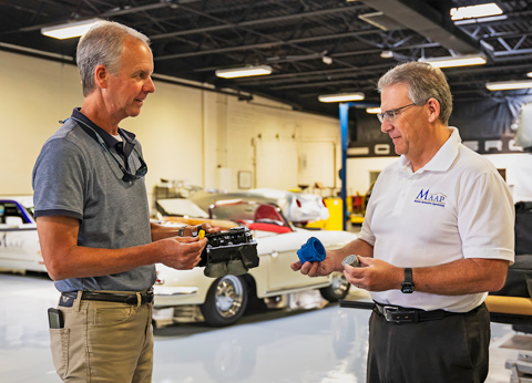 Bill Ritchie, left, and Cole Scrogham, right, in an automotive shop