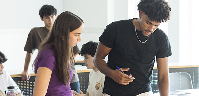 A diverse group of students collaborating in a classroom setting, focusing on a project together.