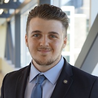 Headshot of Jacob McMurdy in a suit, smiling. 
