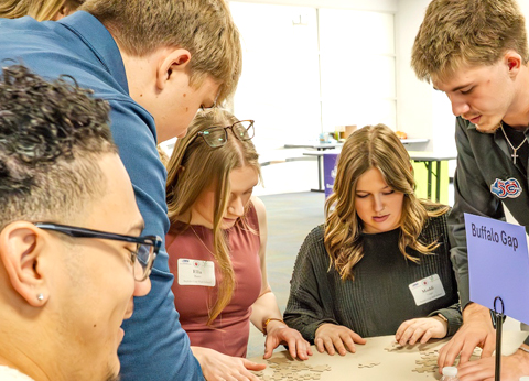Local high school students gathered around a table, collaborating on a hands-on activity.