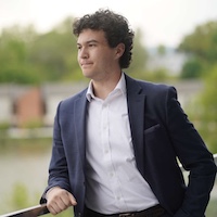 Ryan Degaraff looking over a balcony, dressed in a suit