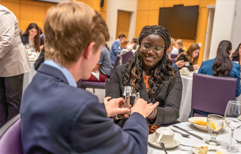 Two students at the etiquette dinner, smiling