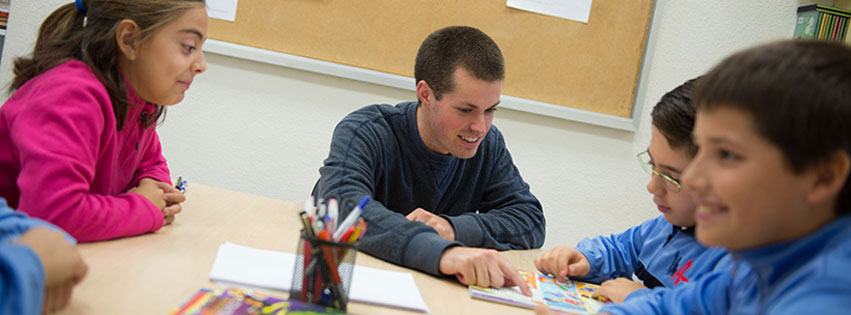 A JMU student teacher assists local children with their assignment