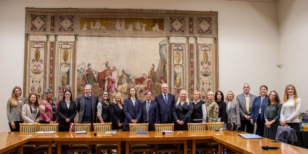 Group of people standing around conference table