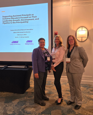 Three women stand in from of a presentation screen at Easter Educational Research Association