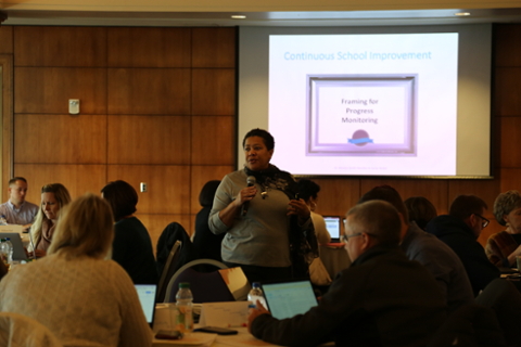 person speaking in front of slideshow